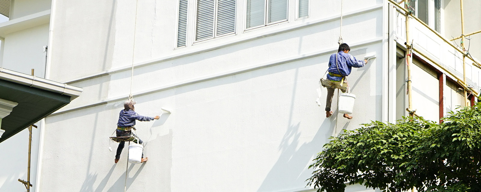 Deux professionnels qui opèrent le ravalement d'une façade