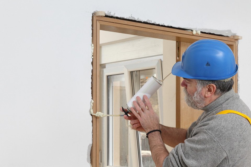 Maçon qui effectue le murage d'une fenêtre